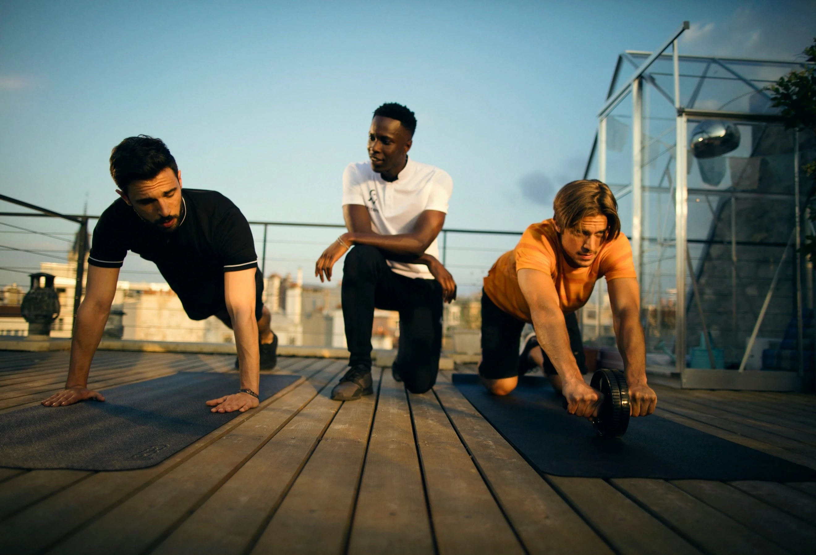 Trois adultes en tenue de sport, en extérieur, en ville.